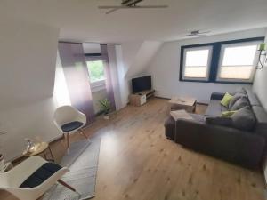 ein Wohnzimmer mit einem Sofa und einem TV in der Unterkunft Ferienwohnung im Manbach in Freudenstadt
