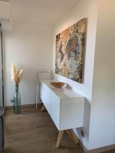 um armário branco num quarto com uma pintura na parede em Magnifique appartement pied dans l'eau em Cannes