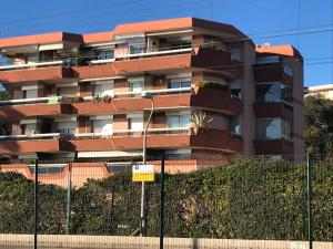 um edifício de apartamentos com uma cerca em frente em Magnifique appartement pied dans l'eau em Cannes