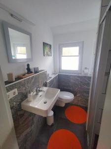a bathroom with a white sink and a toilet at Ferienwohnung im Manbach in Freudenstadt