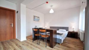 een slaapkamer met een bed, een tafel en stoelen bij Ow Alfa in Rewal