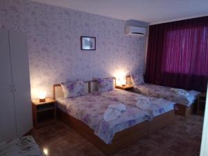 a bedroom with two beds and two lamps on tables at NELLY Guest House in Ravda