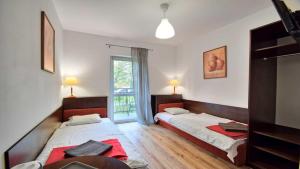 een slaapkamer met twee bedden en een raam bij Ow Alfa in Rewal