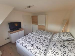 a bedroom with a bed and a flat screen tv at Ferienwohnung im Manbach in Freudenstadt