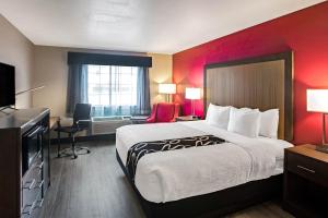 ein Hotelzimmer mit einem großen Bett und einem Schreibtisch in der Unterkunft La Quinta by Wyndham Fort Smith in Massard