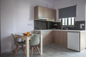a kitchen with a table and two chairs and a sink at Gold Apartments in Platanes