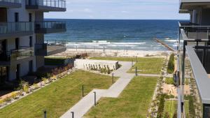 a view of the beach from the balcony of a building at OPAL z widokiem na morze w Gardenia Sea Side Dziwnów in Dziwnów