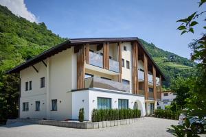ein großes weißes Gebäude mit einem Holzdach in der Unterkunft Residence Laitacherhof - Modern eingerichtete Apartments in der Nähe vom Zentrum von Klausen mit WLAN Südtirol Card inklusive in Klausen