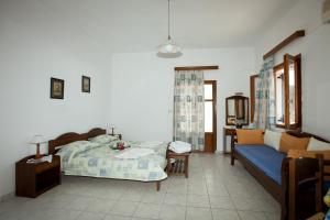a bedroom with a bed and a couch at Apolafsis Studios in Patmos