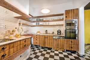 a kitchen with wooden cabinets and a checkered floor at Lemon Tree Stay in Faro