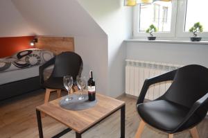 two black chairs and a table with wine glasses at Zacisze in Rozalin