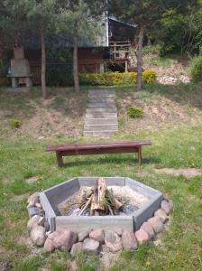 eine Feuerstelle mit einer Bank in einem Park in der Unterkunft Domek nad jeziorem in Wielki Głęboczek