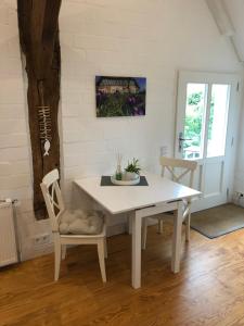 a dining room with a white table and chairs at Bielenberg 37 in Kollmar