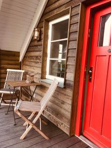 a porch with a table and chairs and a red door at Katjas Kate Mansarde in Prerow
