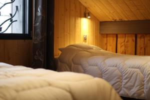een slaapkamer met twee bedden en een raam bij chalet bel horizon La Montagne Des Lamas in La Bresse