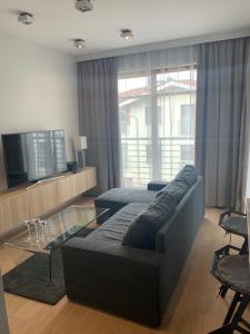 a living room with a couch and a tv at On THE MOON APARTAMENT in Gdańsk