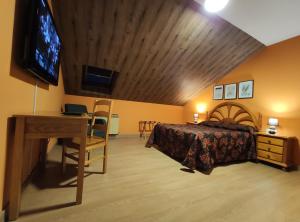 Un dormitorio con una cama, un escritorio y un televisor. en Hostal-Restaurante Paris, en Forcarei
