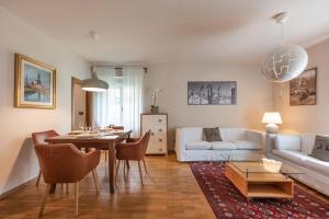 - un salon avec une table et un canapé blanc dans l'établissement Villetta Vallesinella, à Madonna di Campiglio