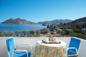 a table and chairs on a balcony with a view of the water at Apolafsis Studios in Patmos