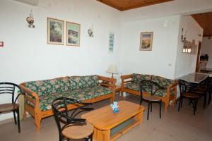a living room with couches and tables and chairs at Apolafsis Studios in Patmos