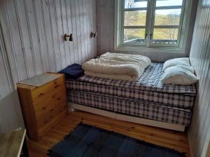 een kleine kamer met een bed en een raam bij Sinnes Fjellstue Apartment 1F in Tjørhom