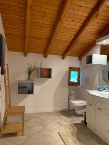Giornicoにあるグロット パーゴラの木製の天井のバスルーム(白いトイレ付)
