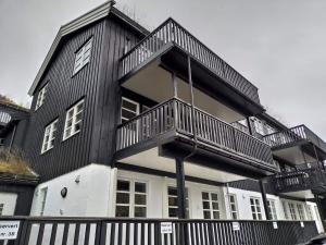 een zwart-wit huis met een balkon bij Sinnes Fjellstue Apartment 1F in Tjørhom