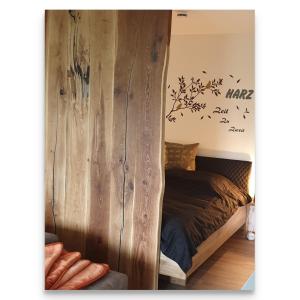 a bedroom with a wooden wall with birds on it at Harz Zeit in Altenau