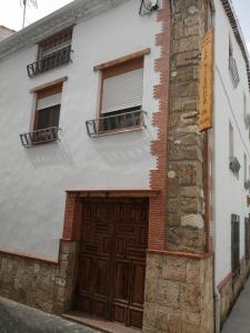 een wit gebouw met een grote houten deur bij nueva tienda de felipe apartamento LA TIENDA in Pontones
