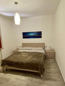 una camera da letto con un letto e un dipinto sul muro di Villa Ombretta a Capoliveri