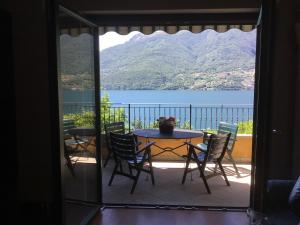 a table and chairs on a balcony with a view of a lake at Casa Elisabetta in Dervio