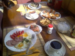 a table with plates of breakfast foods and a cup of coffee at Guest House Melon in Jūrmala