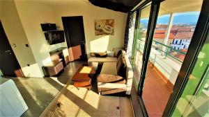 ein Wohnzimmer mit einem Sofa und einem Balkon in der Unterkunft Sunny Days - Park Apartment in Sandanski