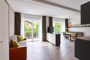 ein Wohnzimmer mit einem Sofa und einem Tisch mit einem TV in der Unterkunft Residence Laitacherhof - Modern eingerichtete Apartments in der Nähe vom Zentrum von Klausen mit WLAN Südtirol Card inklusive in Klausen