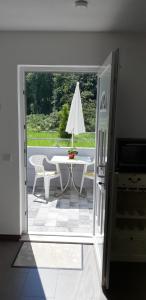 una puerta abierta a un patio con mesa y sombrilla en "Klein & Fein", en Überlingen