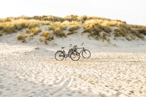 una bicicleta estacionada en la playa en la arena en Hotel Inger, en Hulsig