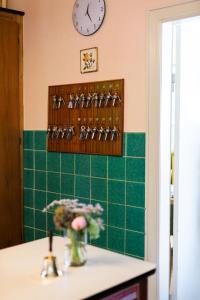 uma casa de banho com uma parede em azulejo verde e um relógio. em Hotel Inger em Hulsig