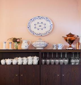 a shelf with china and plates on a wall at Hotel Inger in Hulsig