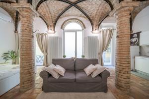 - un salon avec un canapé et des colonnes de briques dans l'établissement Lovely Loft in Reggio Emilia, à Reggio d'Émilie
