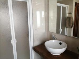 een badkamer met een witte wastafel en een spiegel bij LA TRASTIENDA de felipe in Pontones