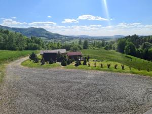 an empty road leading to a house in a field at Górska Hacjenda in Brenna +19 photos