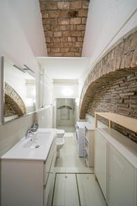 La salle de bains est pourvue d'un lavabo et d'un mur en briques. dans l'établissement Lovely Loft in Reggio Emilia, à Reggio d'Émilie