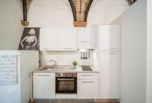 a kitchen with white cabinets and a sink at Lovely Loft in Reggio Emilia in Reggio Emilia