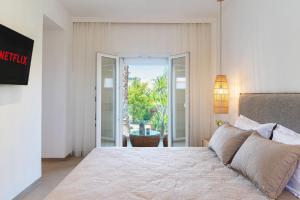 a bedroom with a bed and a sliding glass door at Christa Luxury Apartments in Kavos +57 photos