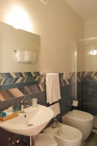 a bathroom with a sink and a toilet and a mirror at Hotel Riviera in Porto San Giorgio