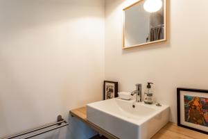 a bathroom with a white sink and a mirror at La chambre de Laura in Castelnau-le-Lez