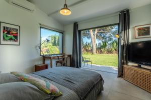 um quarto com uma cama, uma televisão e uma janela em La chambre de Laura em Castelnau-le-Lez