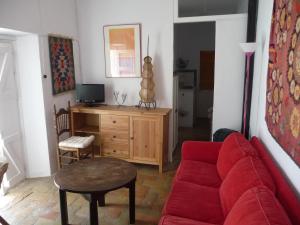 a living room with a red couch and a desk at Casa Sol in Vejer de la Frontera +16 photos