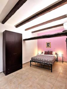 - une chambre avec un lit et un mur violet dans l'établissement Villa PANGALIS Romantica, à Kato Pavliana