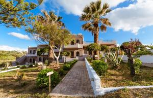 a house on the beach with palm trees at Gregory Village Sea View in Stalos